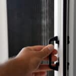 Man Opening a Security Screen Door — iQ Shutters in Warana QLD